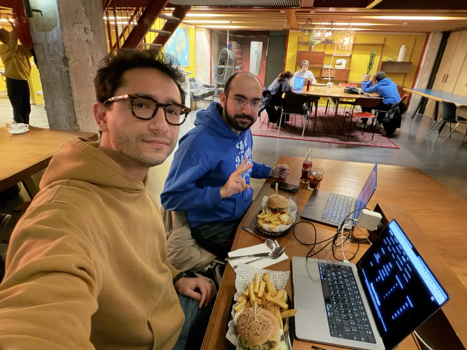 Alireza and Sepehr working on Cask Studio at a table in an Amsterdam café, two laptops open between them